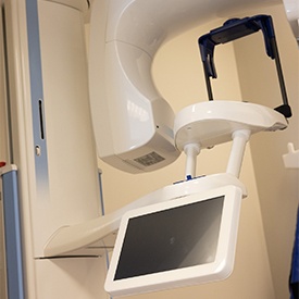 Implant dentist pointing at an X-ray with a patient